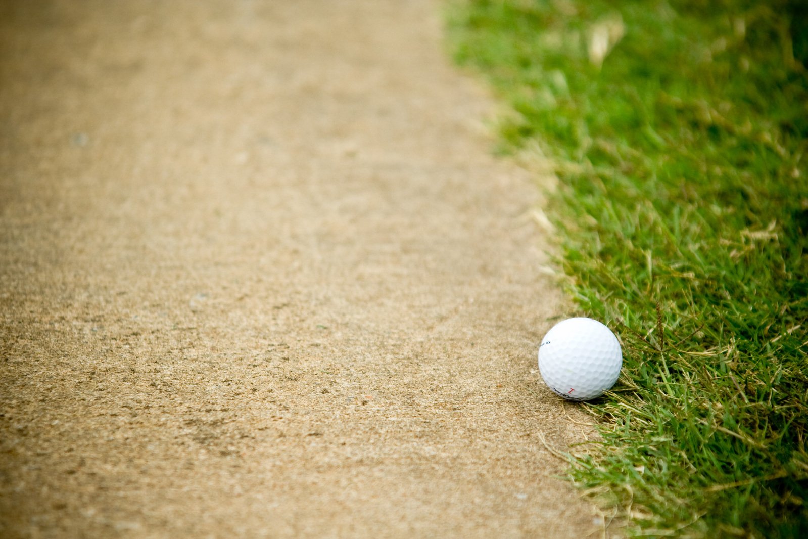 a small golf ball laying on the side of a road
