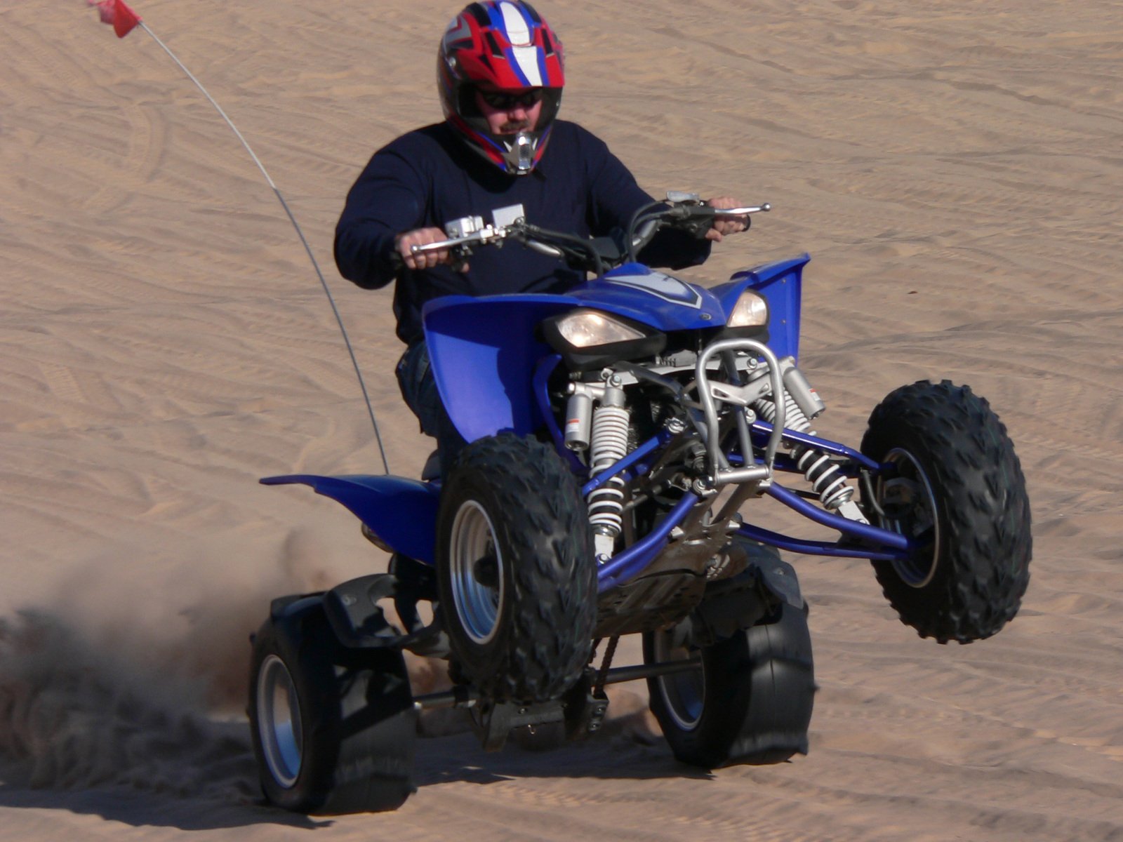 a man on a small blue four wheeler