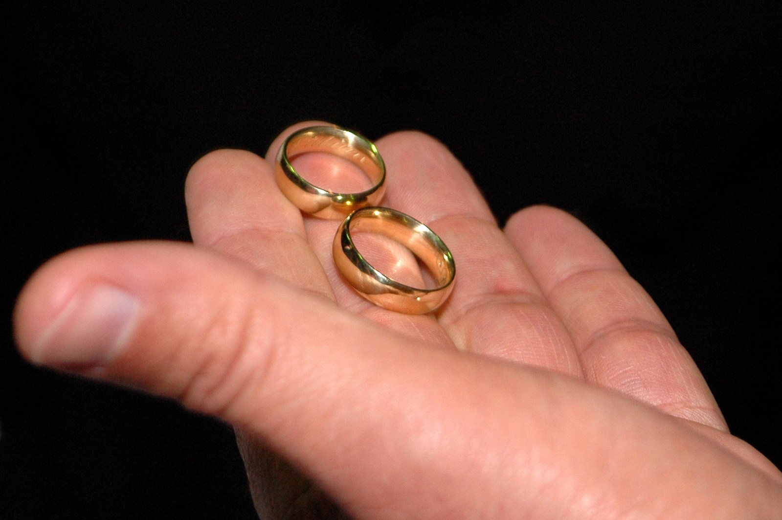 there are two gold wedding rings in the palm