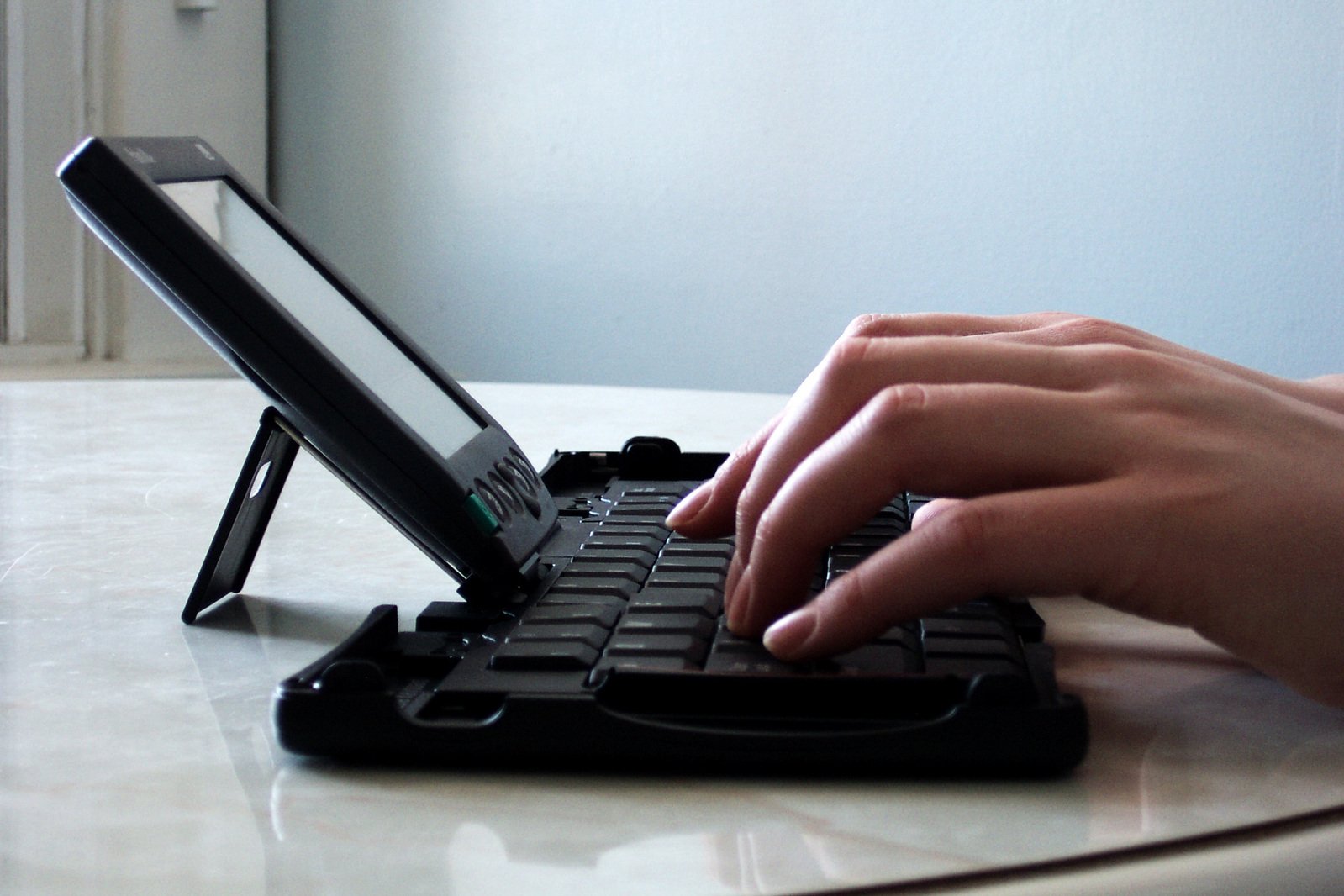 a hand typing on top of a laptop keyboard