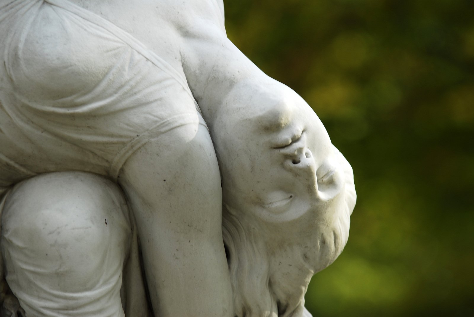 a white statue of a person holding another one