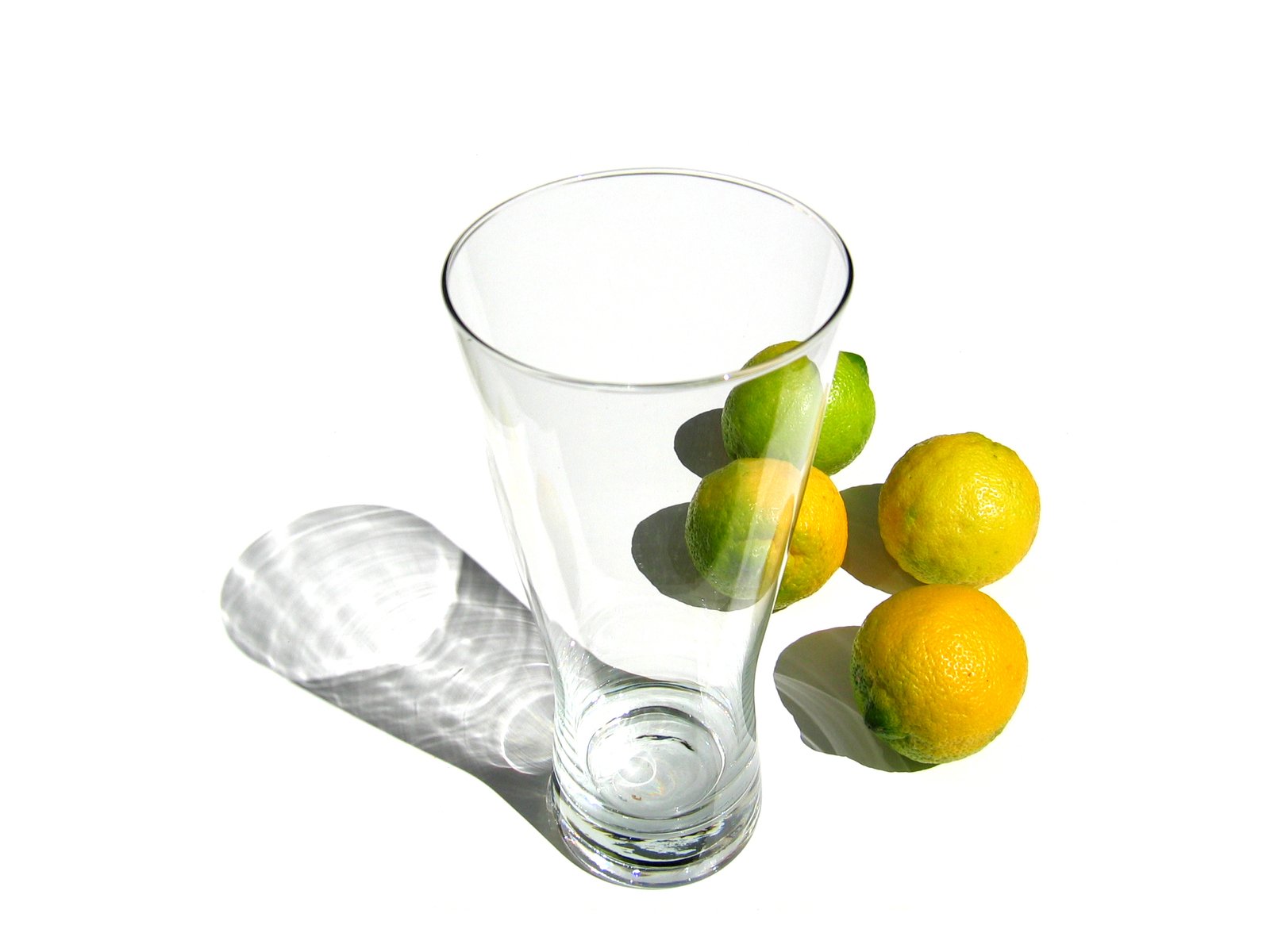 a glass with some lemons and lime wedges in it