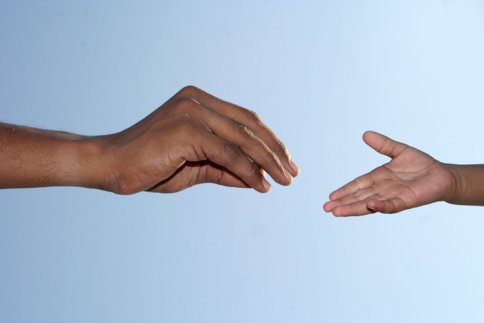 two hands touching each other over a white background