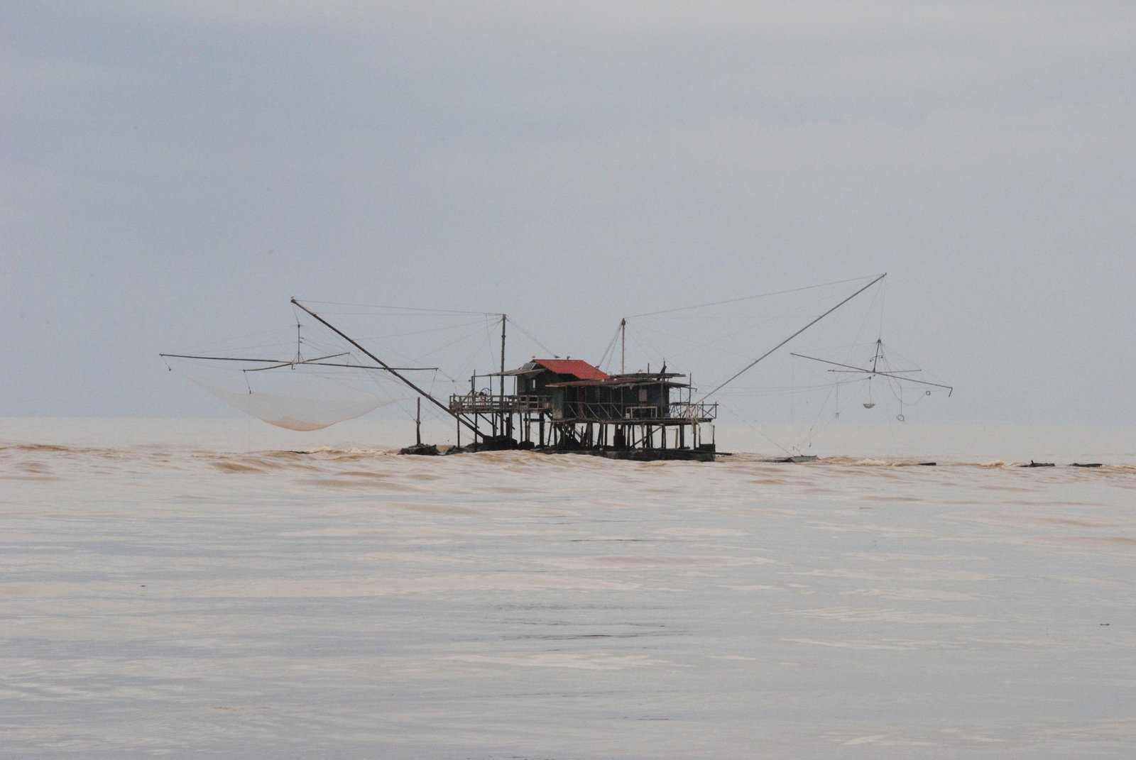 a small house out in the middle of the ocean