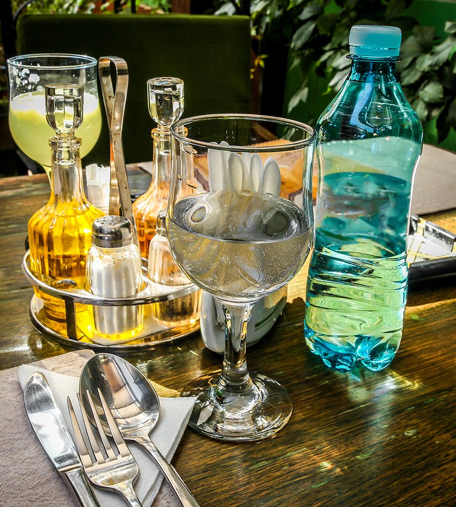 a close up of wine glasses, wine bottle and spoons on a table