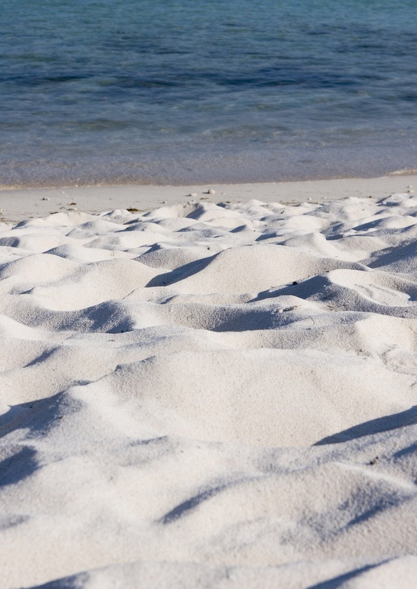 there is sand and the ocean water at this beach