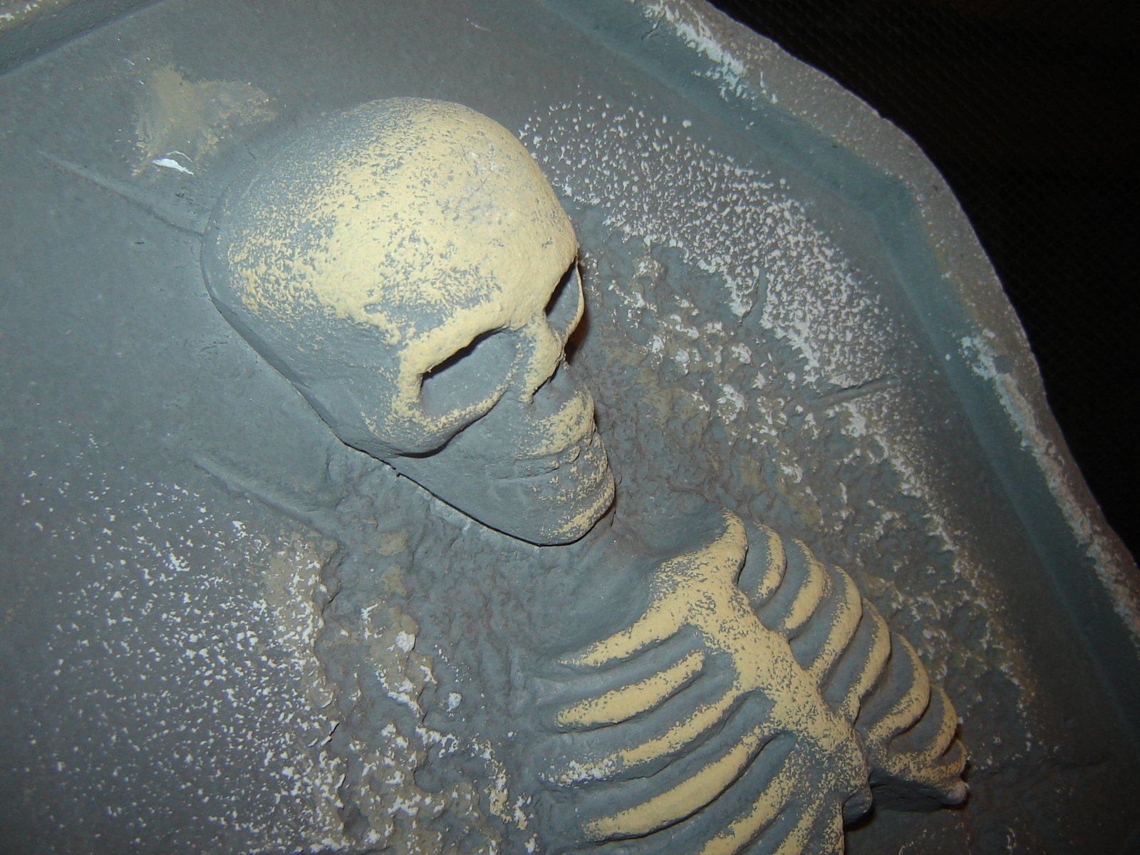 the small carved model of a skeleton sits in a bathtub