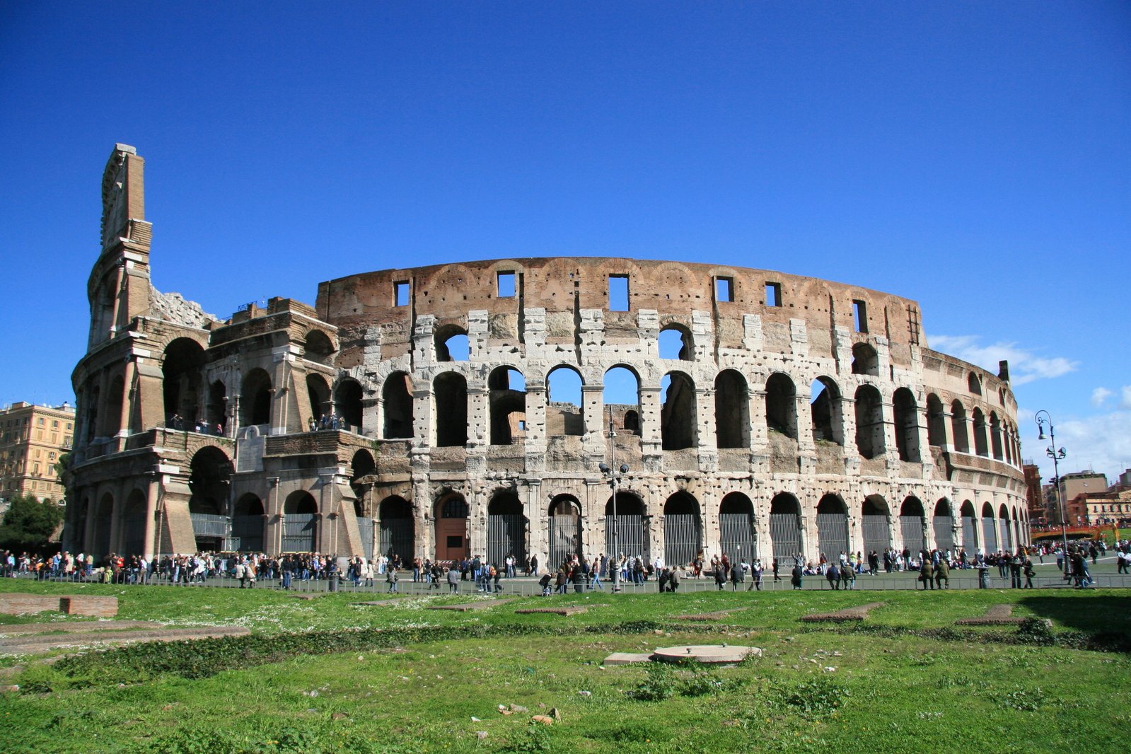 tourists walk inside and around the roman colossure