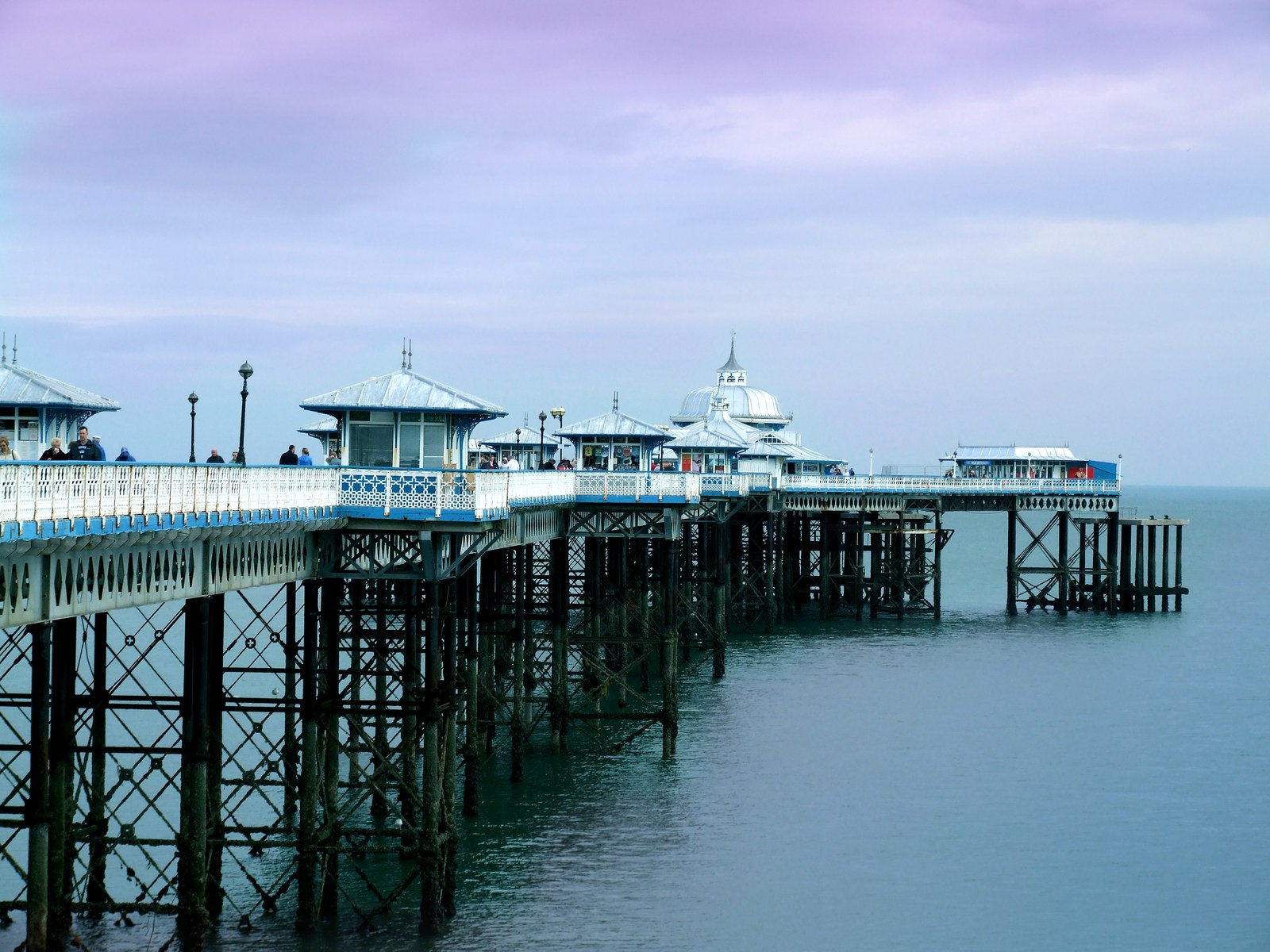 a pier with a long row of houses and people on it