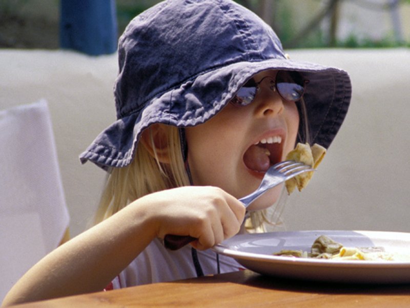 the child is eating food off the plate