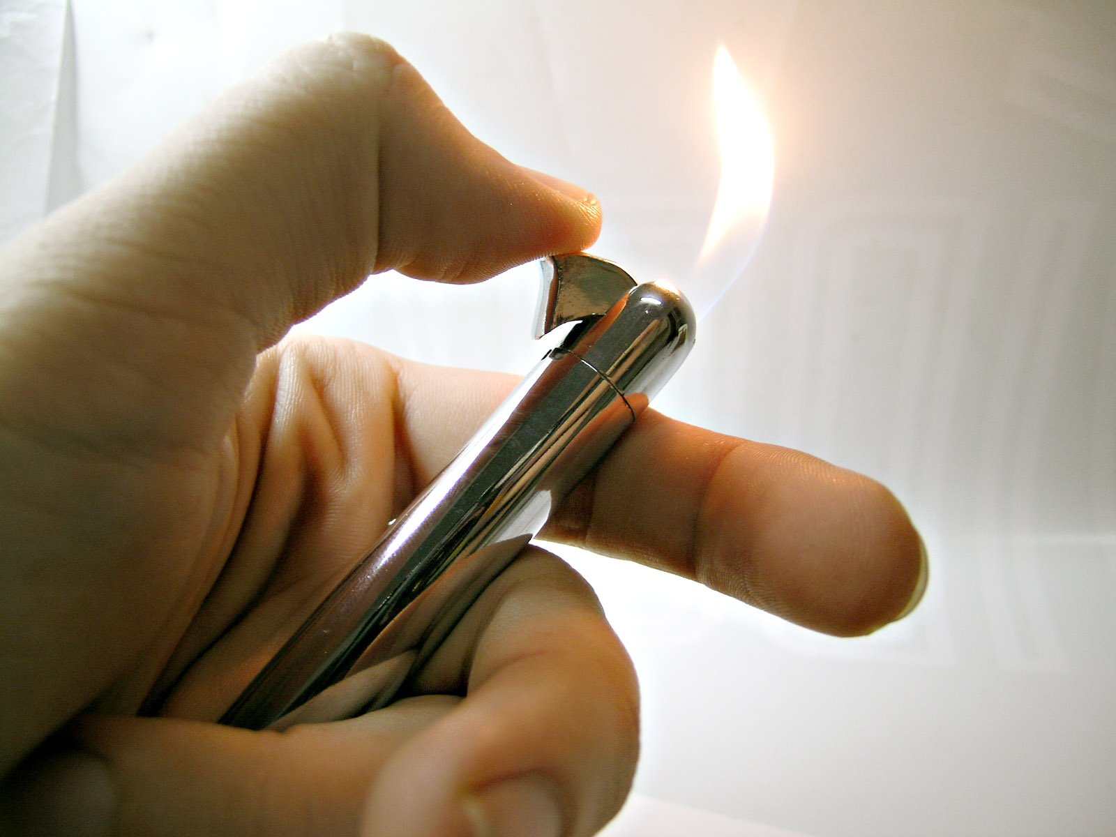 someone holding onto a lighter with a small matchstick