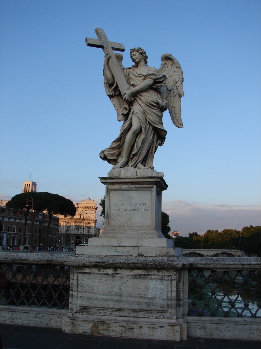 statue of an angel carrying the cross in a city