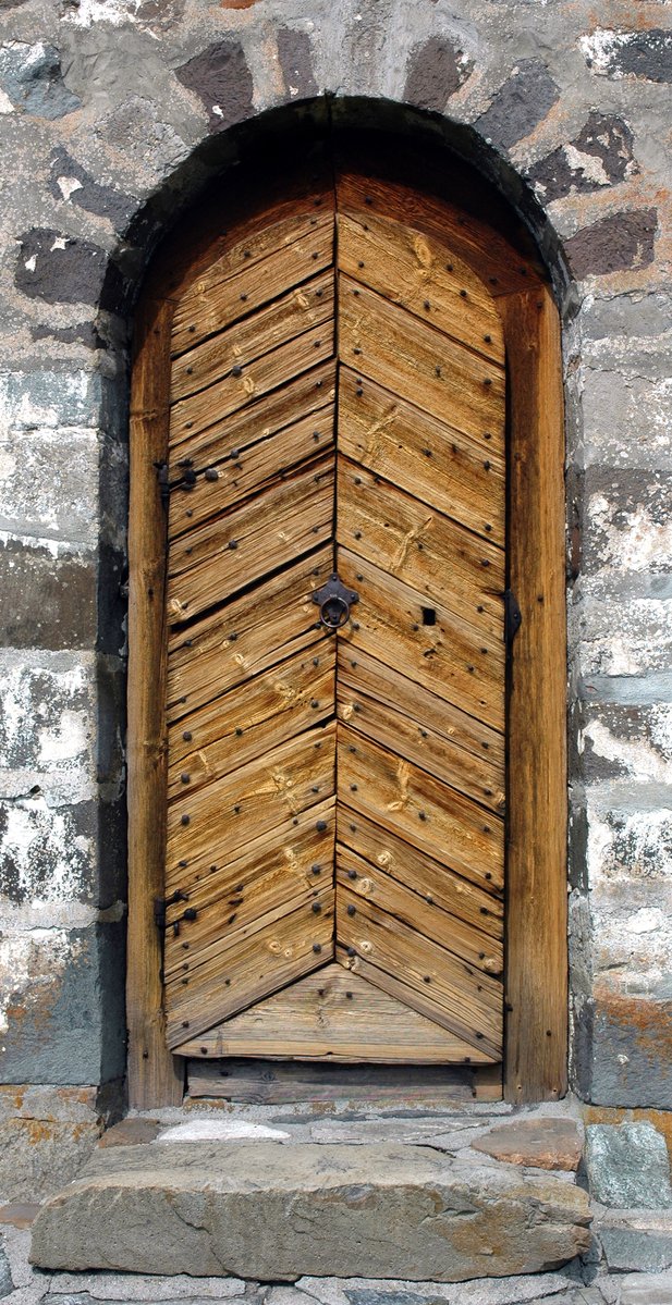 a very big old door with a wooden doorway