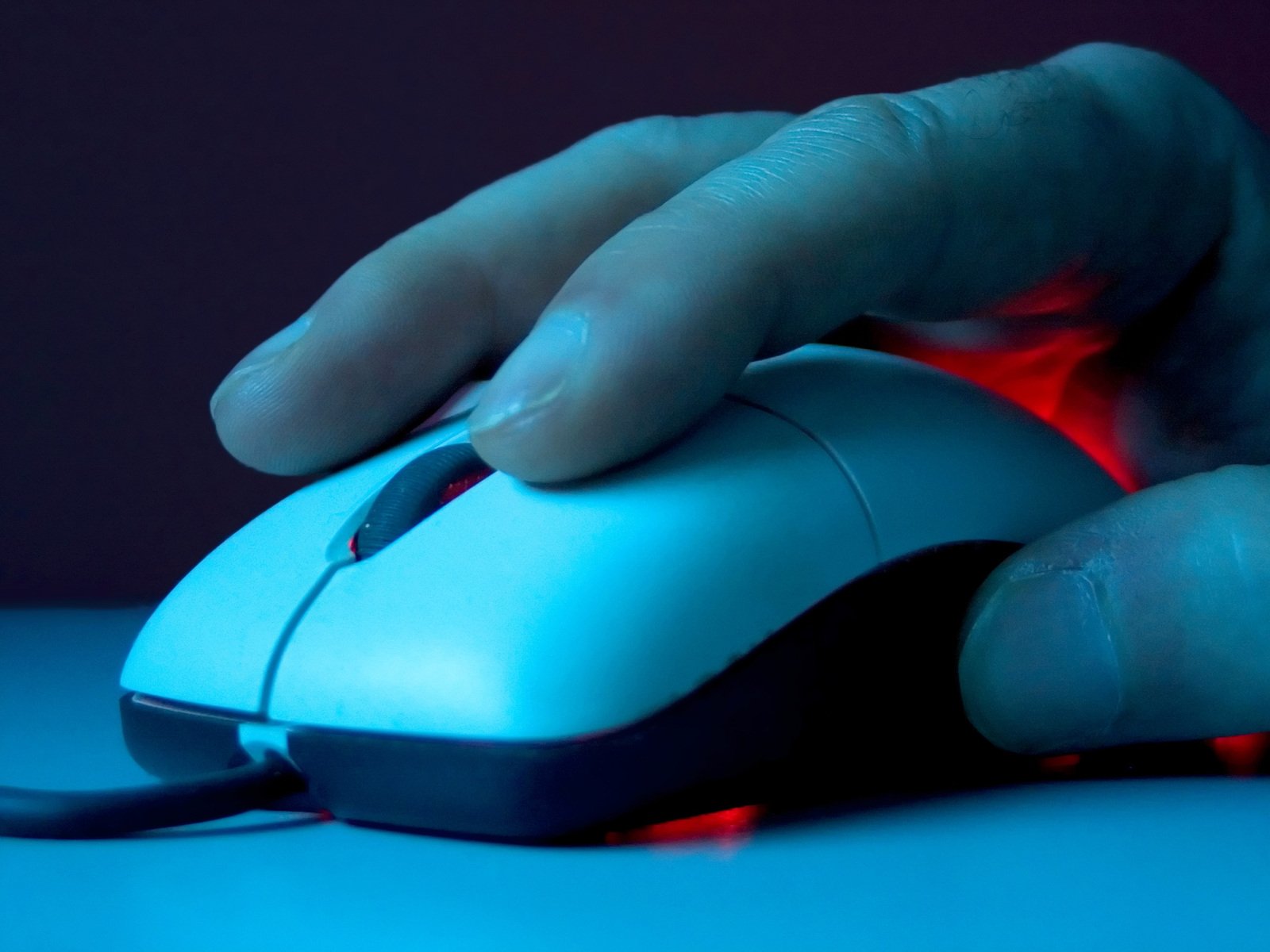 a person holding their hand on the top of a mouse