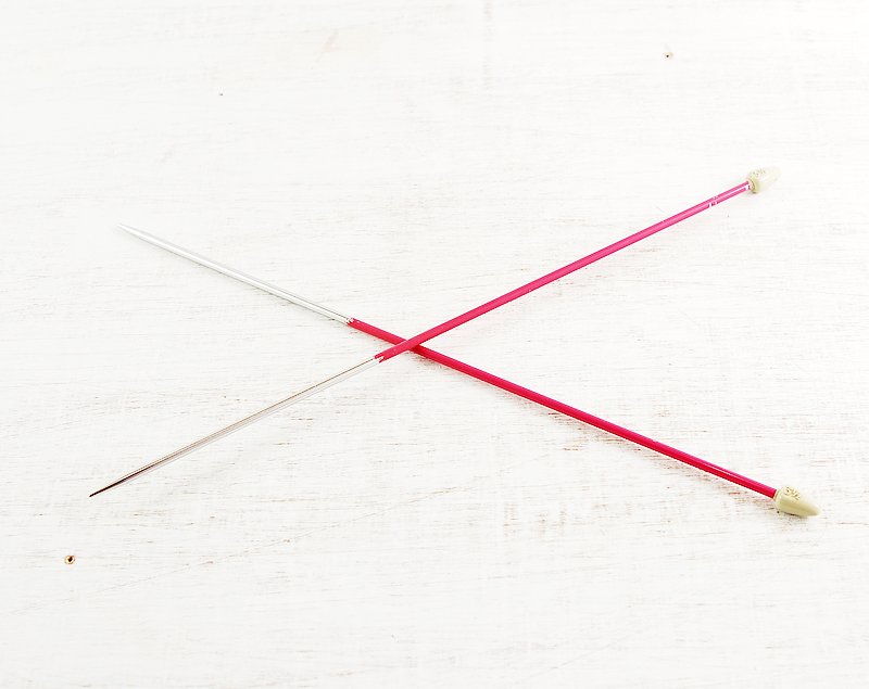 two red toothpicks that are sitting on top of a wooden table