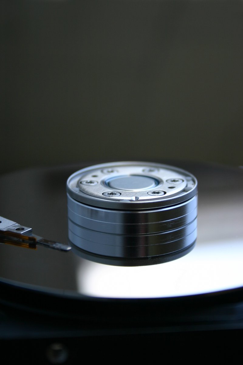 a silver disk is being held by a tweeker