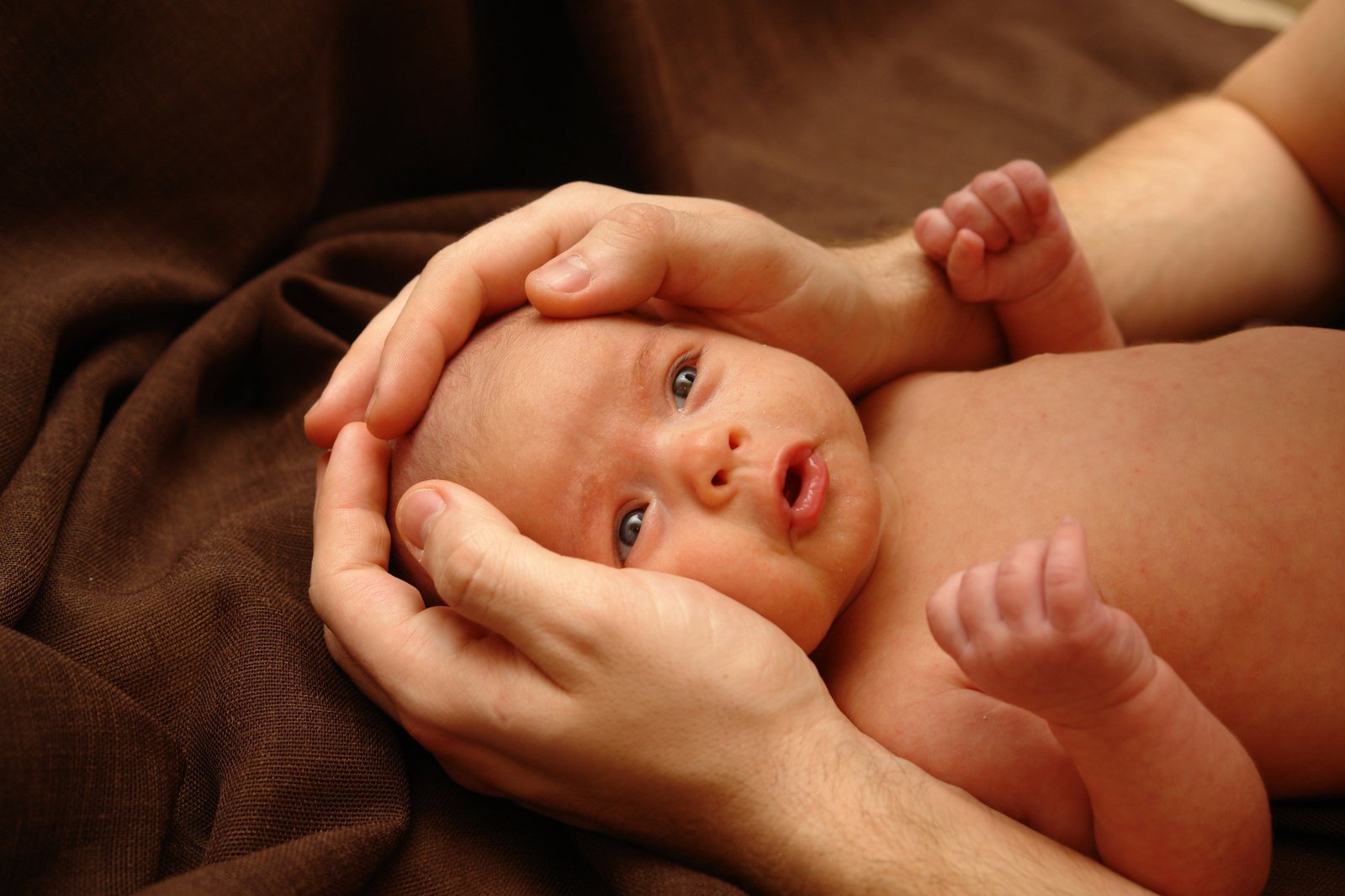 a woman holding onto a baby on top of a bed