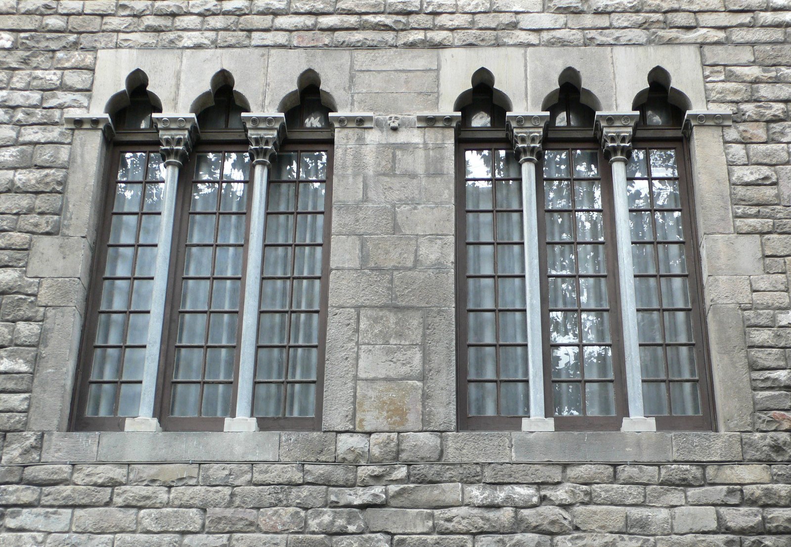 several large windows on a wall made of stone
