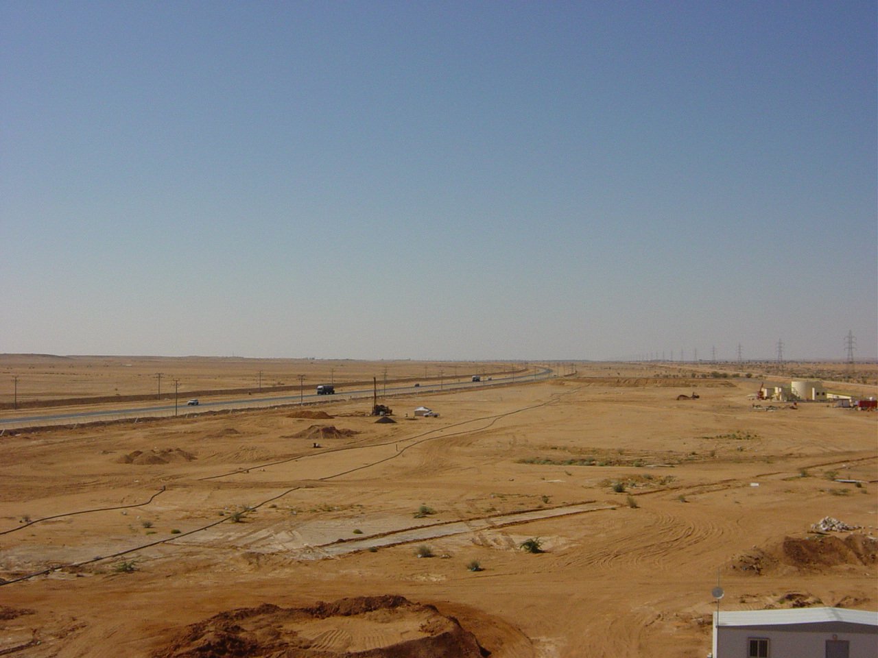 large dirt field area with road in the distance