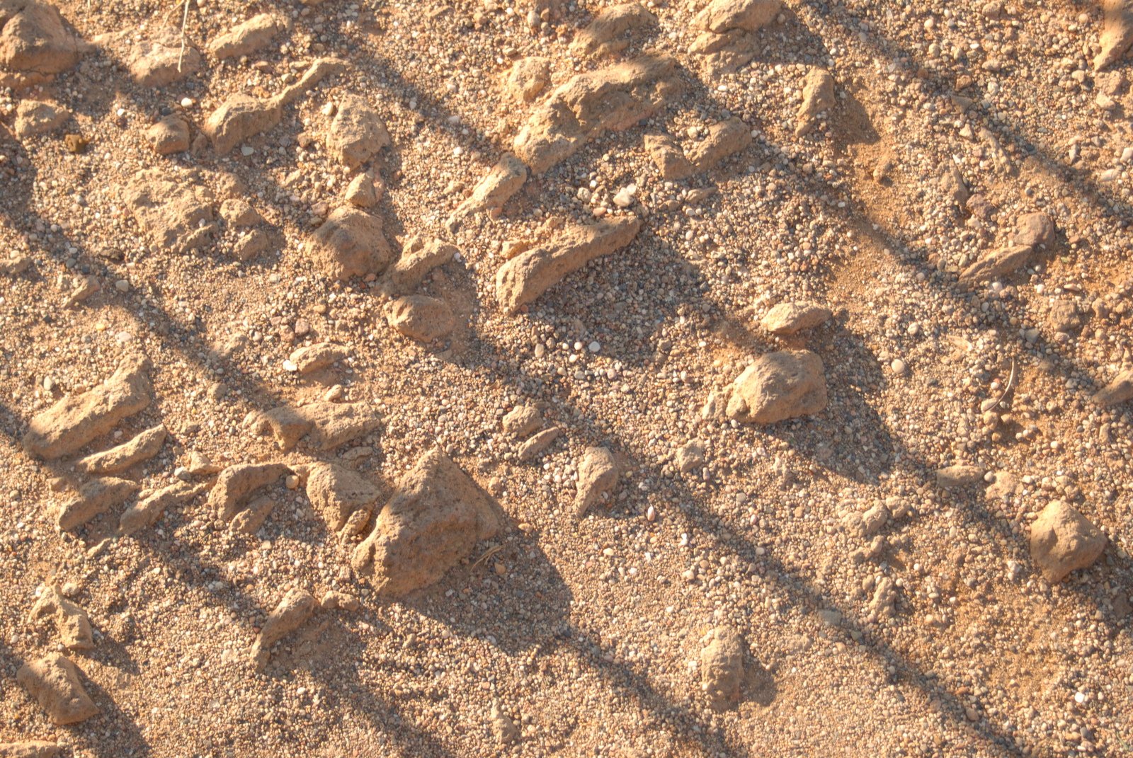 a piece of fence with rocks in the sand