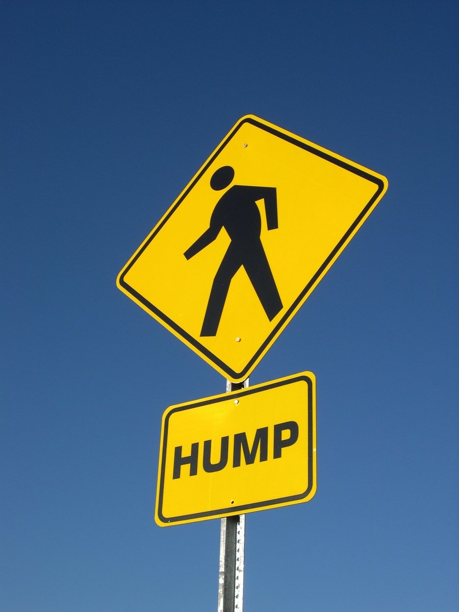 a yellow street sign with the words hump on it