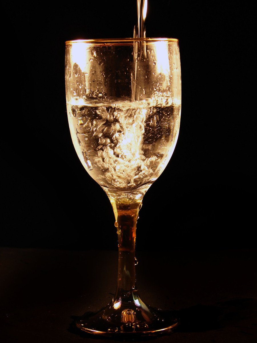 a glass of wine is shown being poured