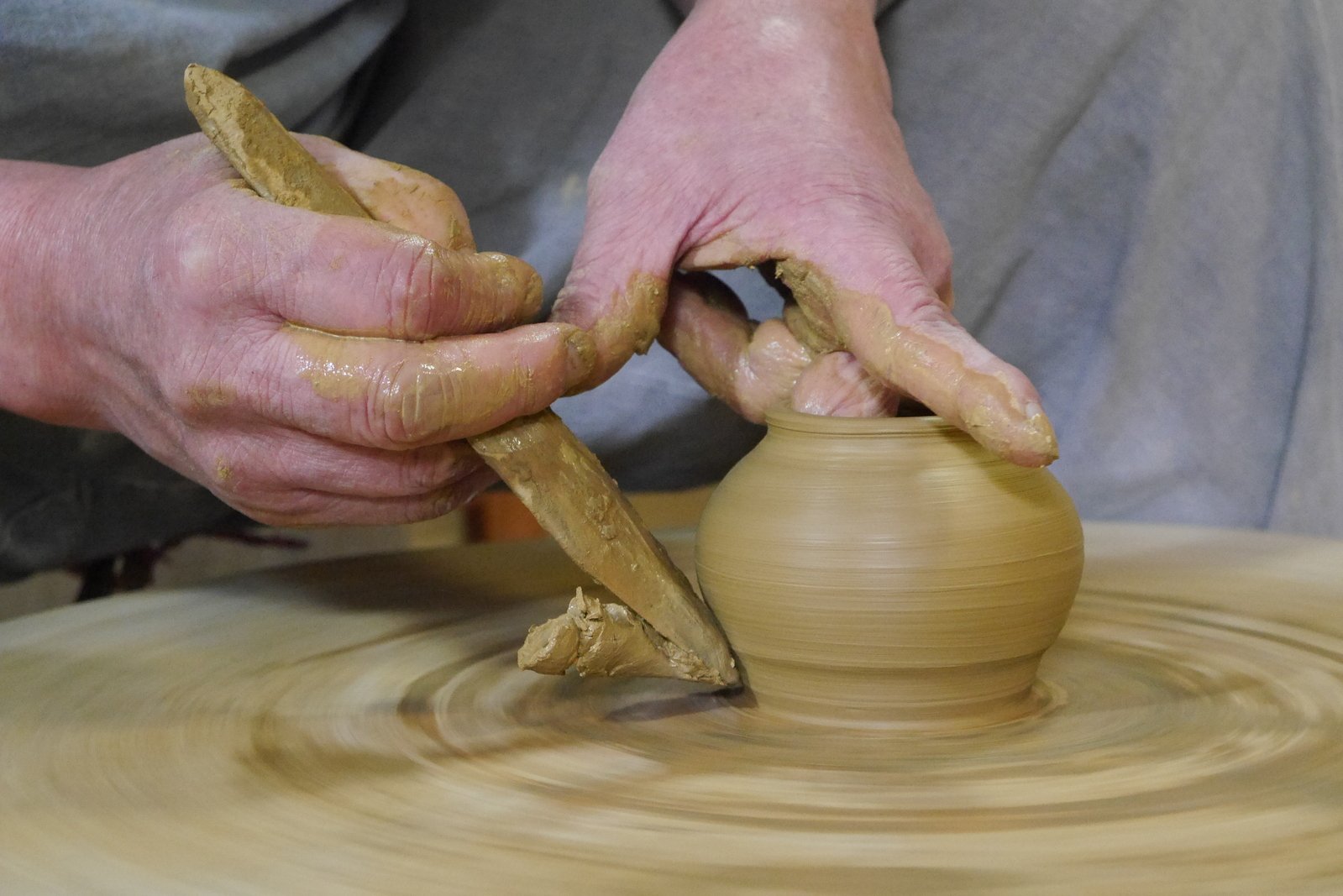 a person holding a potters wheel making a pot