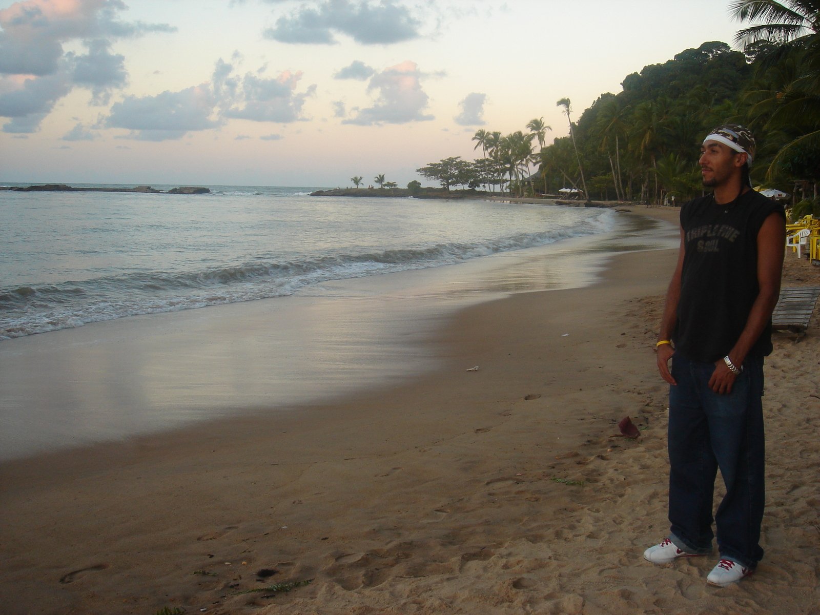 a man is standing on the beach in front of a body of water