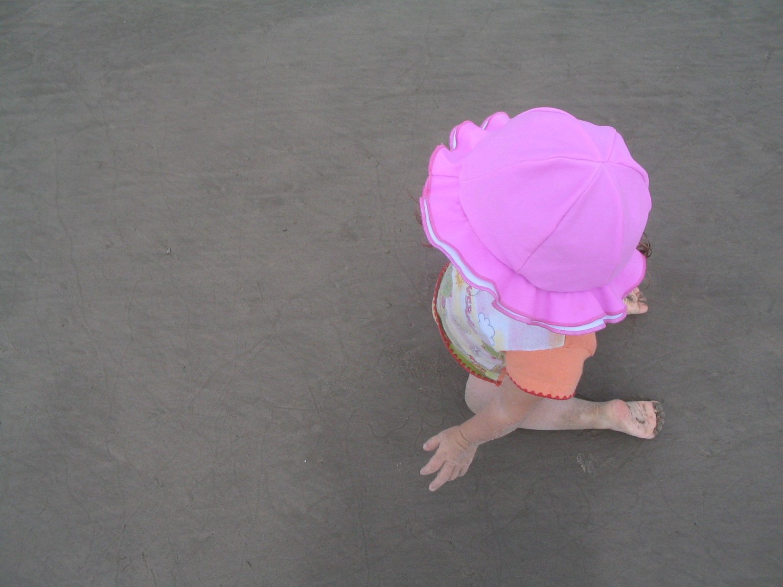 a small child in pink sitting on the ground