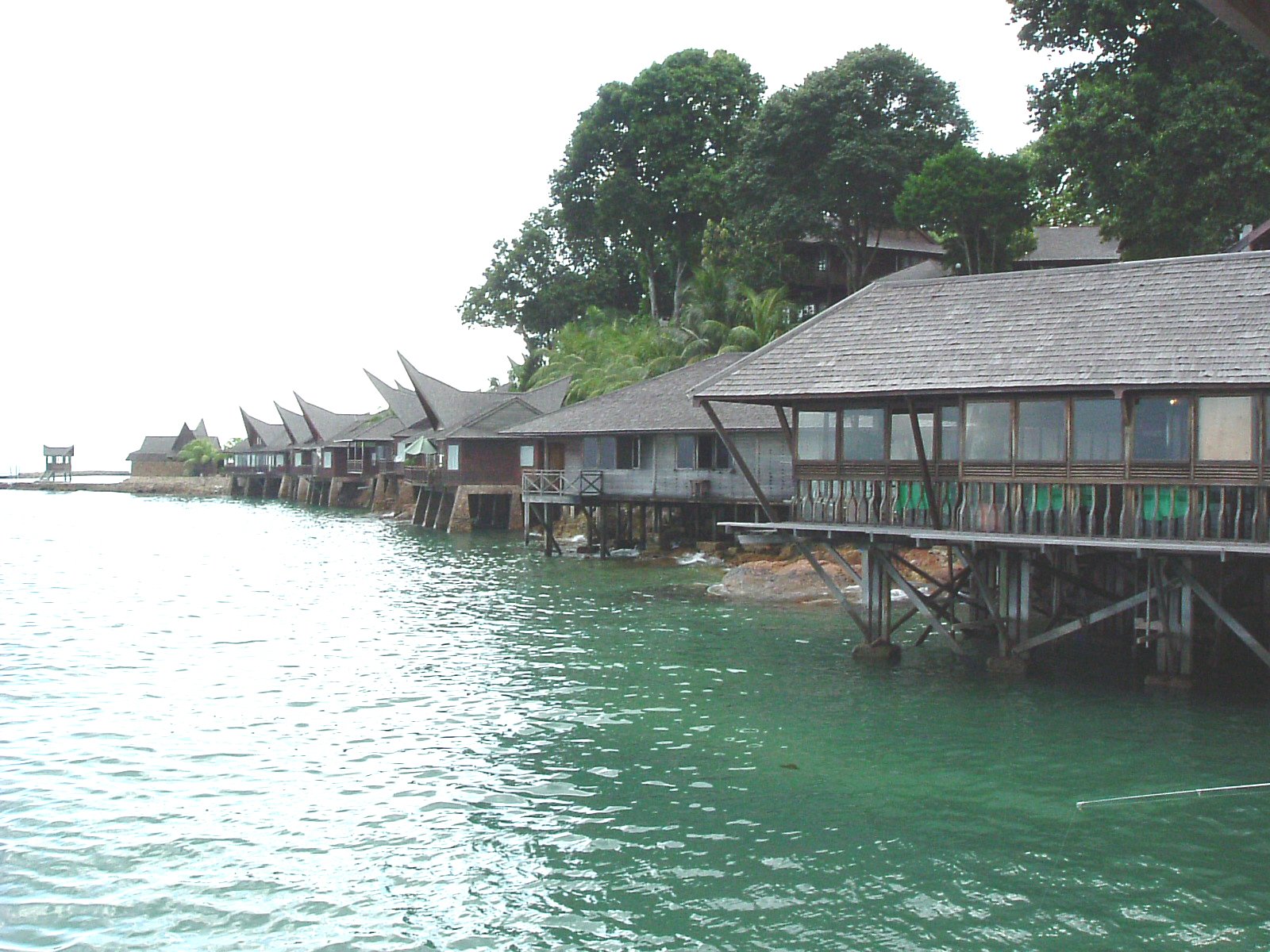 a line of houses sitting on the side of a lake