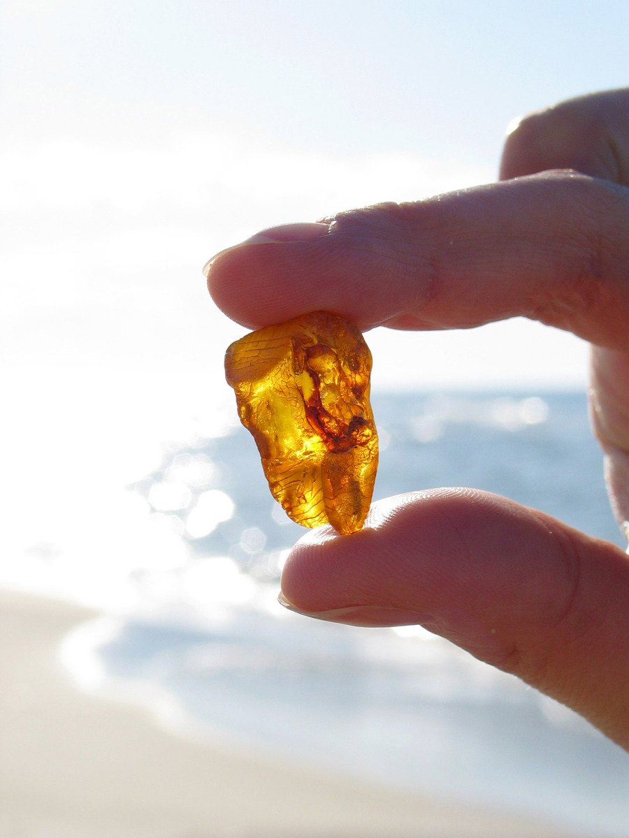 a man holding a piece of yellow glass in his hand