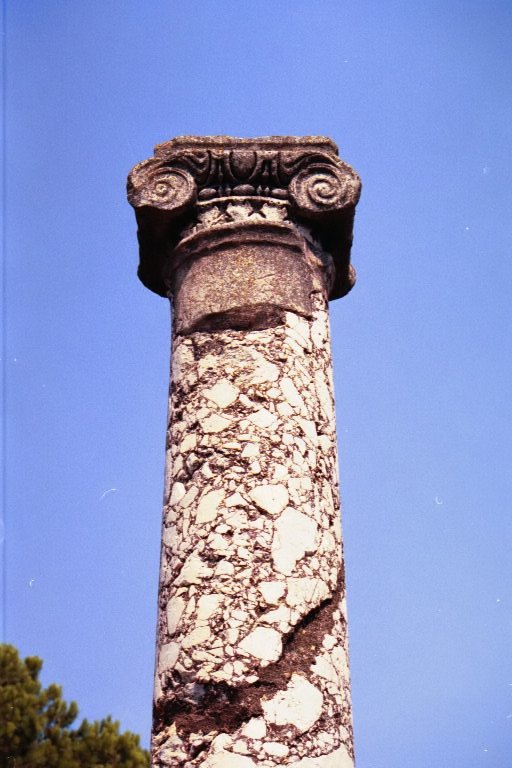 an old column that has been placed in front of a clear blue sky