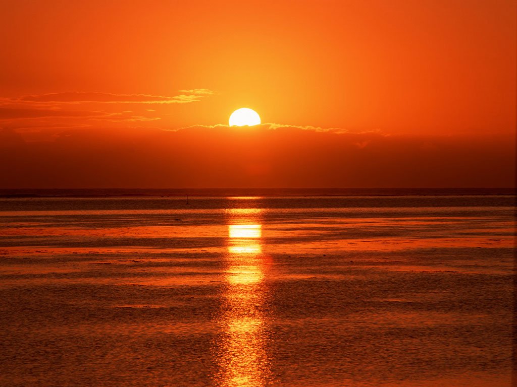 sunset on the water in an orange sky