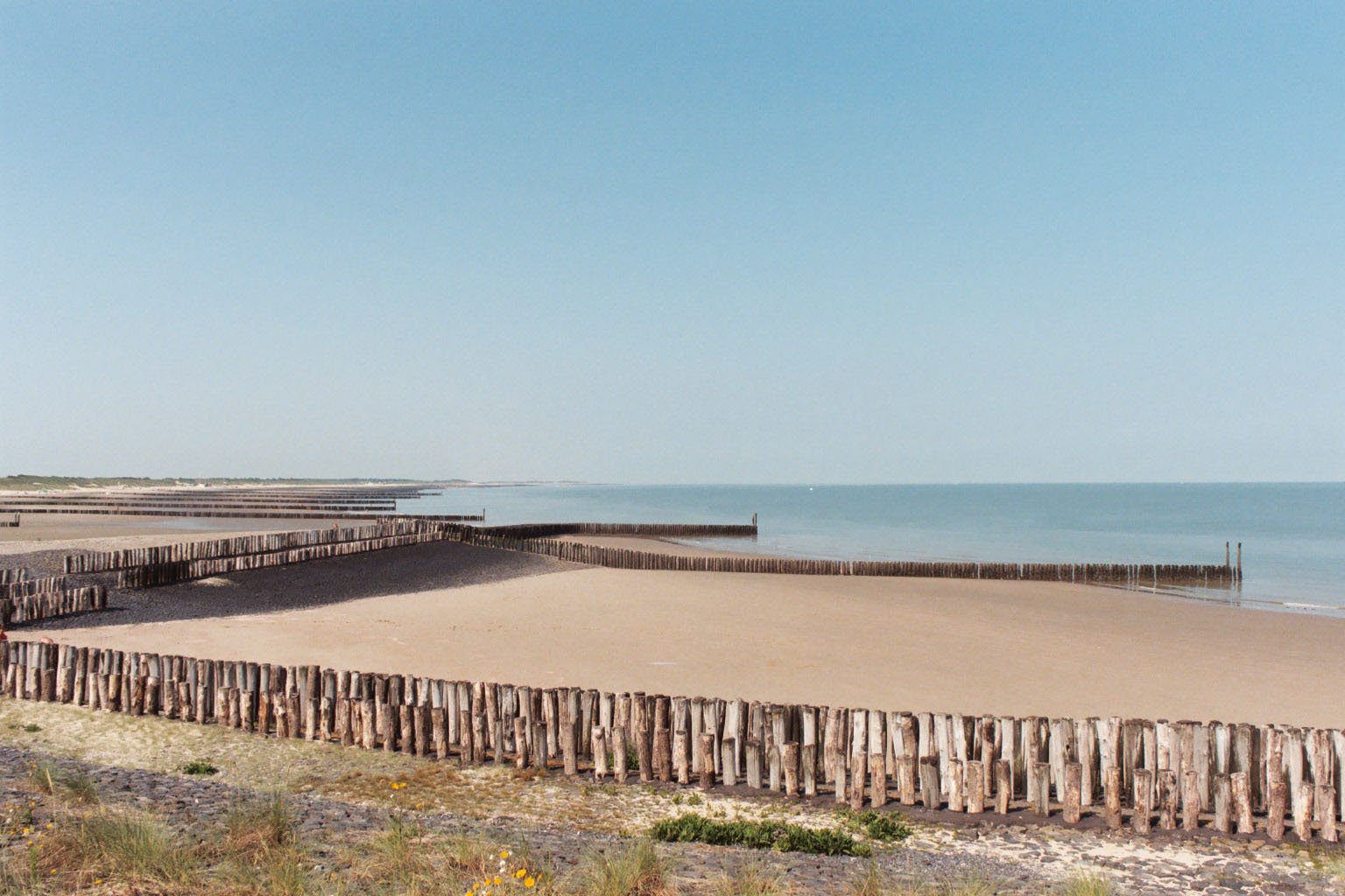 a long wooden fence at the ocean's edge