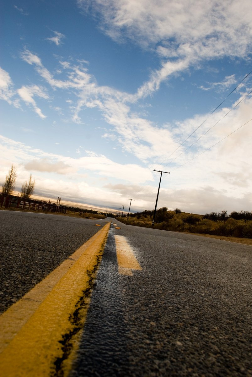 the asphalt with yellow lines and blue skies