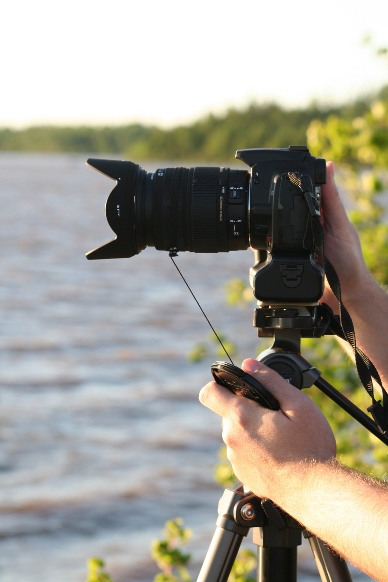 man with camera and microphone recording body of water
