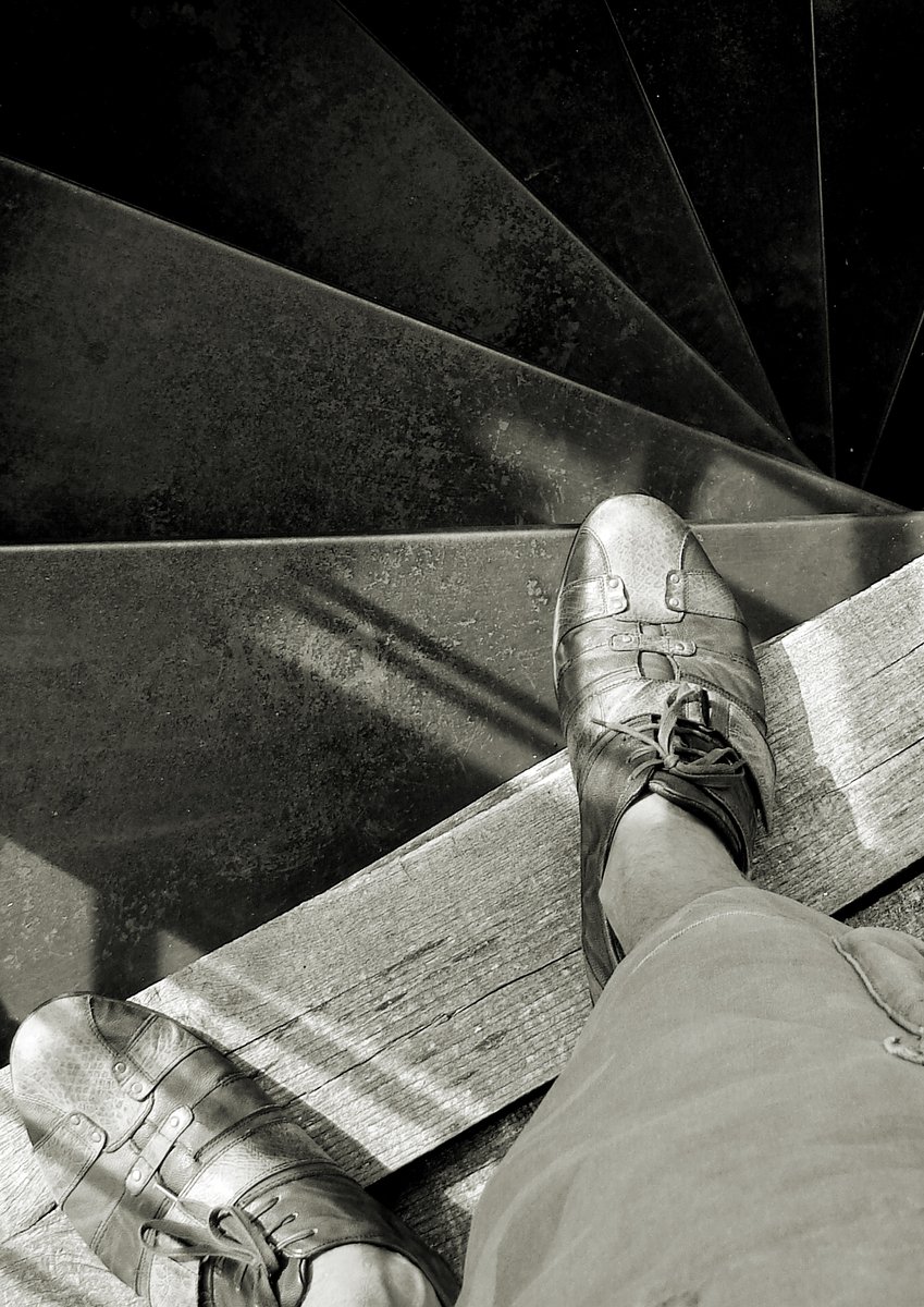 feet in white sneakers sit on stairs