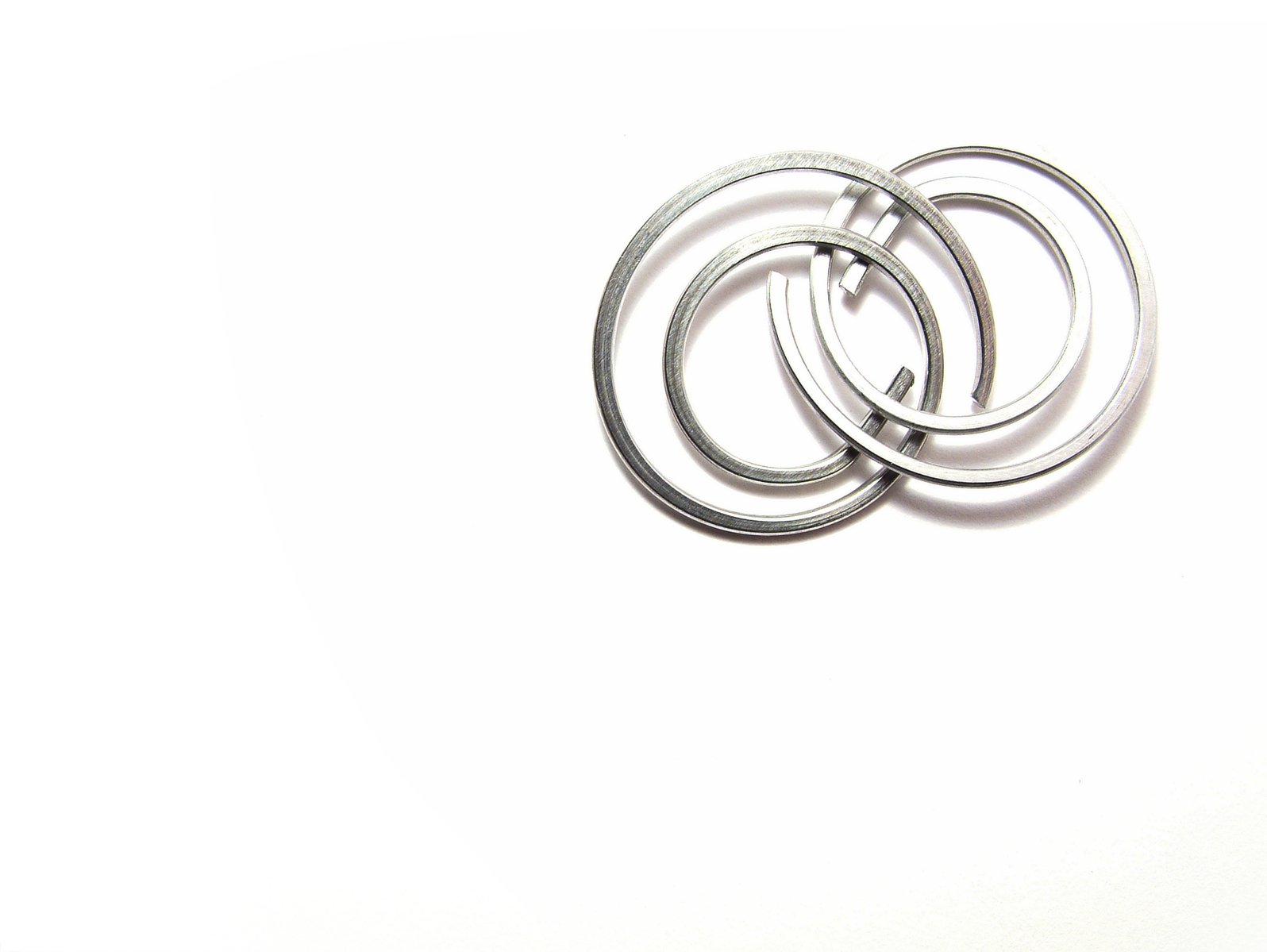 three circular pieces of metal sitting on a white surface