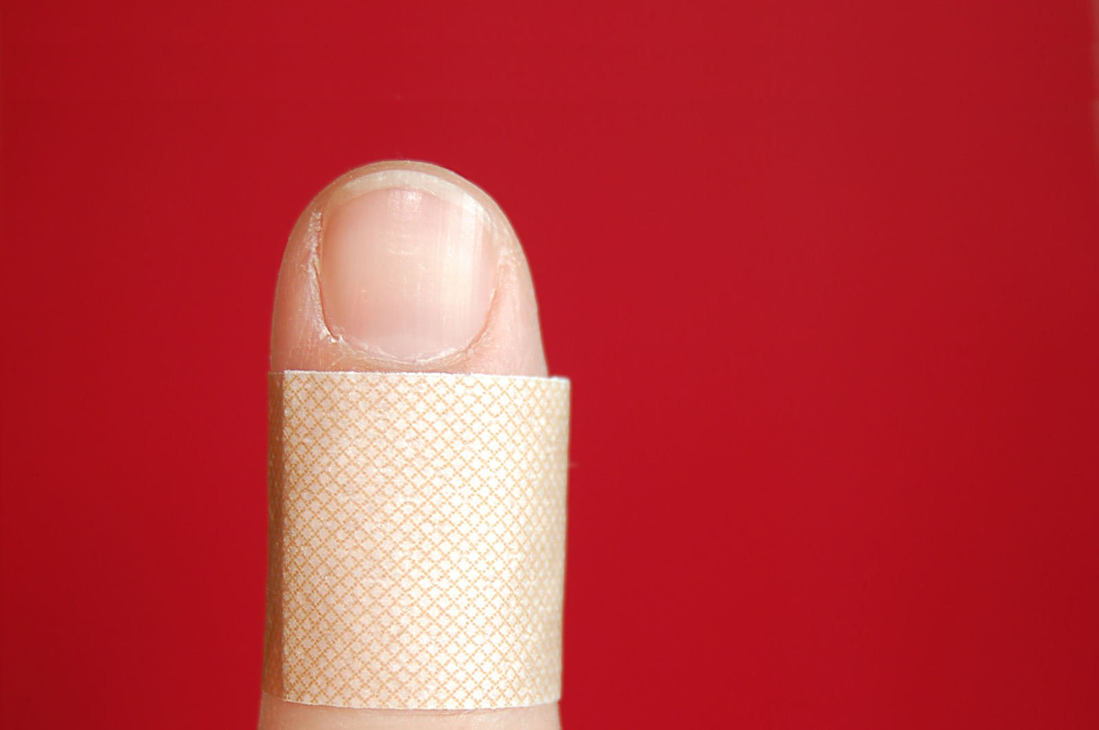 a person holding on to a finger covered in bandages