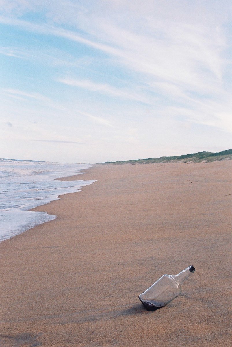 message in a bottle on the beach near the water