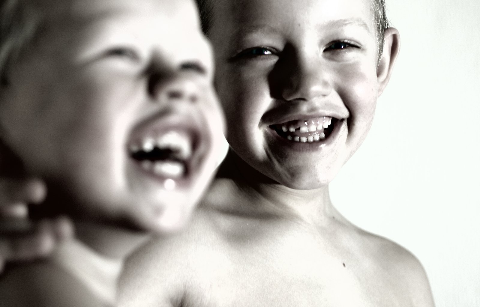 two young s laughing and standing next to each other