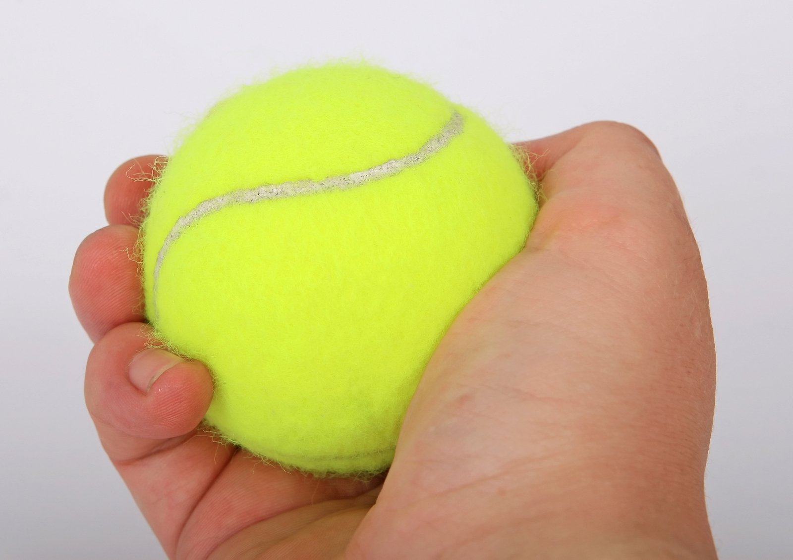 a hand is holding a tennis ball in front of the camera