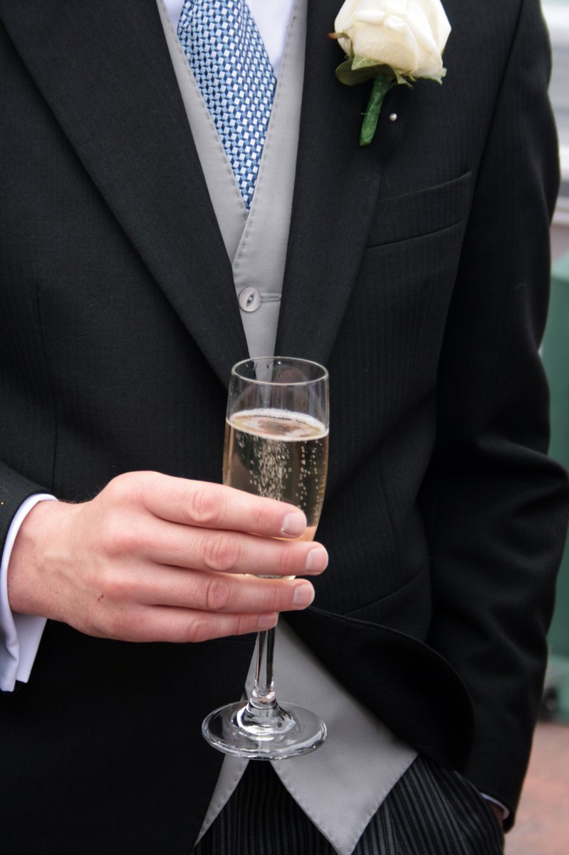 a man wearing a suit and holding a glass with champagne