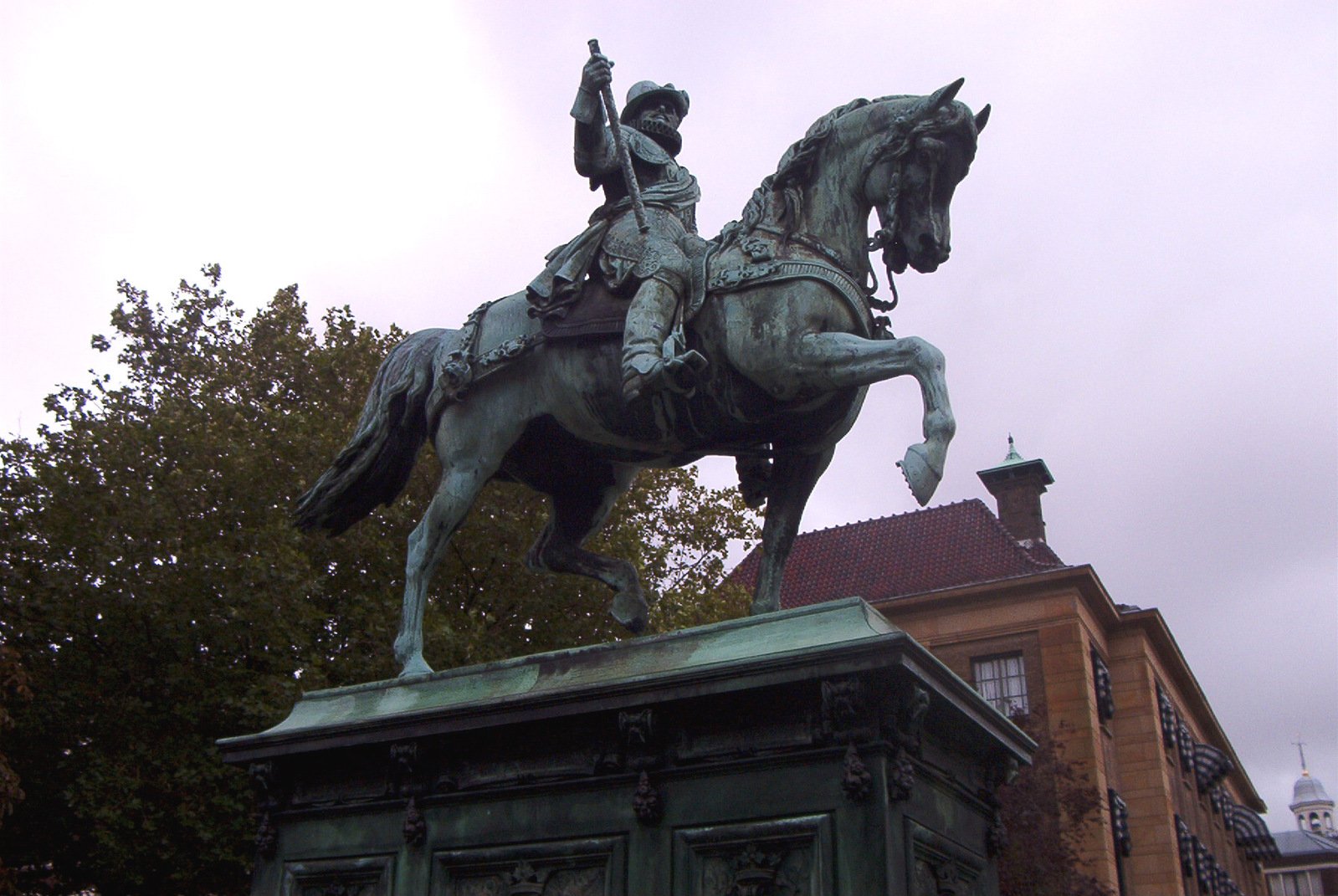 a statue of a man on horseback is located in front of a building