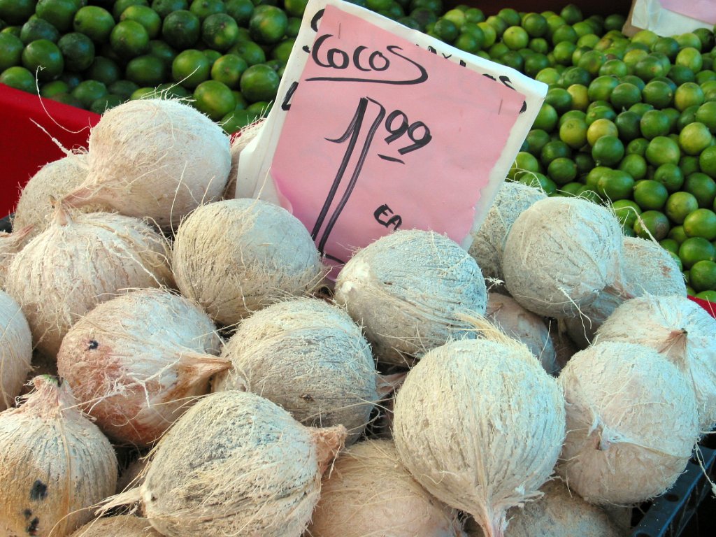 a pile of different types of coconuts in different colors