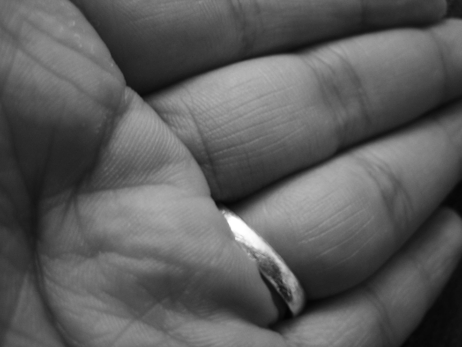 a person holding a hand with a small silver ring in it