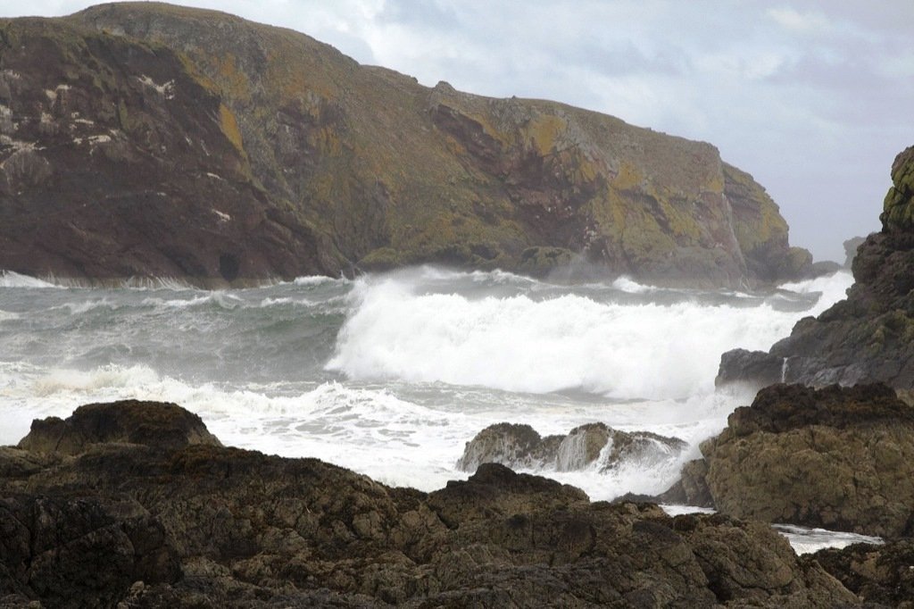 a man is riding his surf board into the water