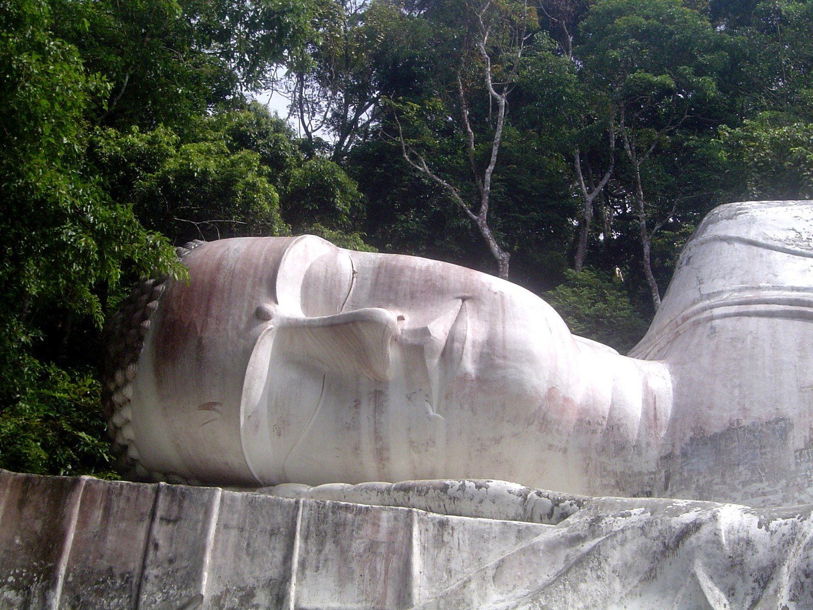 a large white sculpture of buddha laying down