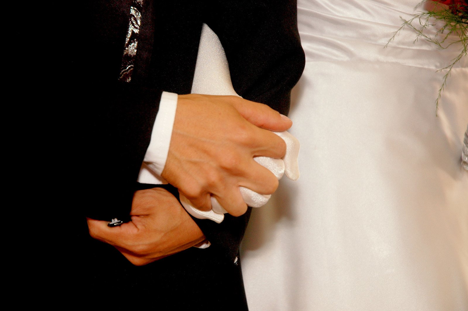 a person wearing a suit and tie holds their hands on their wedding band