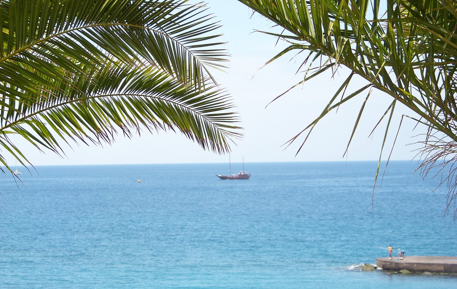 a boat is sailing on the sea near a beach